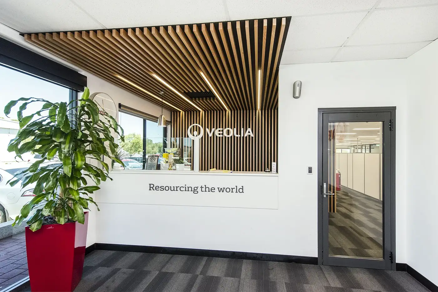 VEOLIA &mdash; reception with a timber batten feature ceiling and wall, and the 'Resourcing the world' counter.